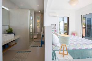 a bedroom with a bed and a bathroom with a sink at Villa Arkoudaki Luxurious Escape with Infinity Pool & Sea Access in Évyiros +56 photos