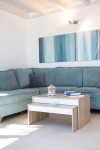 a living room with a blue couch and a coffee table at Villa Amoudia - Luxury Villa right on the beach with Private Pool in Sivota