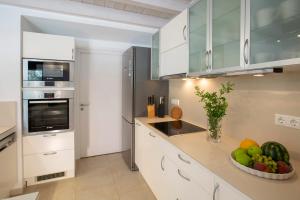a kitchen with white cabinets and a bowl of fruit at Villa Amoudia - Luxury Villa right on the beach with Private Pool in Sivota