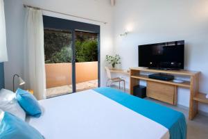 a bedroom with a bed and a flat screen tv at Villa Amoudia - Luxury Villa right on the beach with Private Pool in Sivota +44 photos