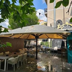 a patio with tables and chairs under an umbrella at The Arlington Boutique Hotel in Craiova