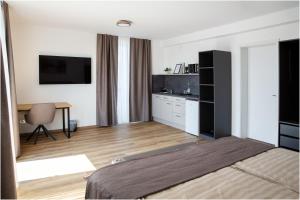 a bedroom with a bed and a desk and a television at Pension Malia in Fronhausen