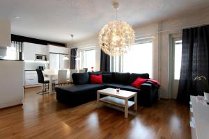 a living room with a black couch and a table at Santalux Apartment 2 in Rovaniemi