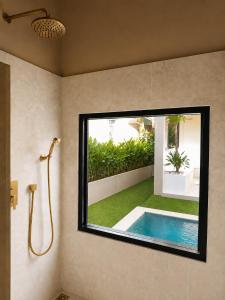 a bathroom with a swimming pool and a window at La Caza Sowana in Ko Phangan