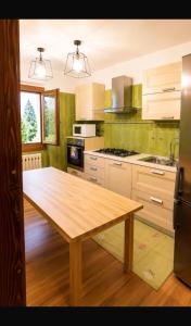 a kitchen with a wooden table in the middle at Appartamento Lisander in Ponte di Legno
