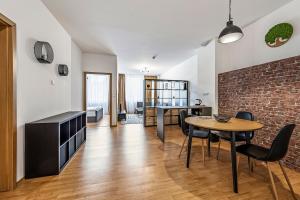 a living room with a table and a brick wall at Hotel Spolcentrum in Jezersko