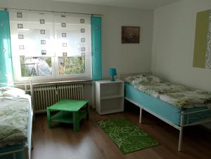 a room with two beds and a table and two windows at Ferienwohnung Jahnke in Burkardroth