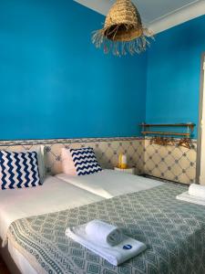 a bedroom with a bed with a blue wall at WOT Lodge Soul in Ericeira