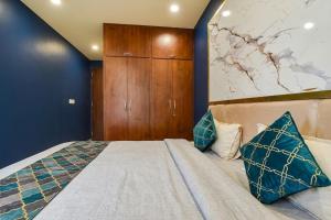 a bedroom with a large bed with blue walls at fabhotel nirmal in Lucknow