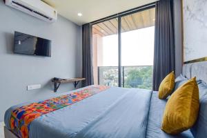 a bedroom with a bed and a large window at fabhotel nirmal in Lucknow