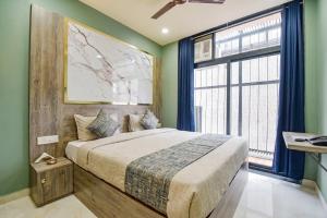 a bedroom with a large bed and a large window at fabhotel nirmal in Lucknow