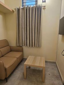 a living room with a couch and a coffee table at Hotel Ferro in Kumbalgod