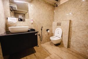 a bathroom with a sink and a toilet in it at Anaya Regency in Naya Bāzār +15 photos