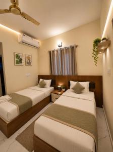 a hotel room with two beds and a window at Hotel Ferro in Kumbalgod