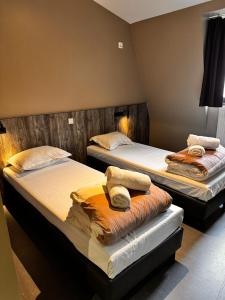 two beds in a hotel room with towels on them at Brxxl 5 City Centre Hostel in Brussels