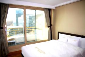 Ein Bett oder Betten in einem Zimmer der Unterkunft Geoje Ocean Hotel