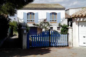 ein blaues Tor vor einem weißen Haus in der Unterkunft Chez Marydidou : Chambres d'hôtes in Istres