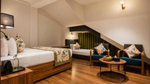 a hotel room with a bed and two chairs at Mount Himalayan Hotel in Gangtok