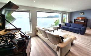 a living room with a couch and a large window at Villa with a view in Ålesund