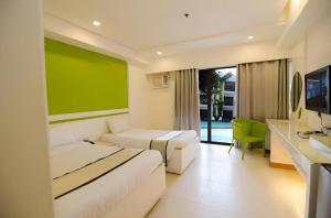 a hotel room with two beds and a television at Apple Tree Resort & Hotel in Opol