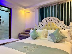 a bedroom with a large white bed and a couch at Shanvilla Resort Ltd in Murangʼa