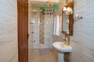 a bathroom with a sink and a toilet and a mirror at Shanvilla Resort Ltd in Murangʼa +55 photos