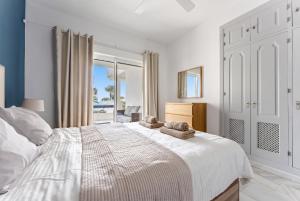 a bedroom with a white bed with towels on it at 203 Arruzafa Sea View in Málaga +17 photos