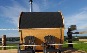 two chairs sitting in front of a dog house at The Snuggly Sheep Farm Stay Shepherd Hut in Ballyshannon