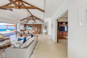 a living room with a white couch and a dining room at Villa with exclusive views in Marigot
