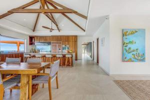 a dining room and kitchen with a wooden table and chairs at Villa with exclusive views in Marigot