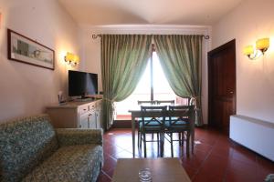 a living room with a couch and a table with chairs at Mercure Argentario Hotel Filippo II in Porto Santo Stefano