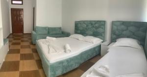 a bedroom with two beds and a couch at Kiki Hotel in Velipojë