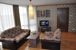 a living room with a couch and a tv at Elija apartments Palanga (Sventoji) in Palanga