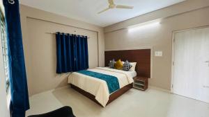 a bedroom with a bed with a blue curtain at Fabhotel Aman palace in Mumbai