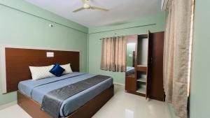a bedroom with a bed and a ceiling fan at Fabhotel Aman palace in Mumbai