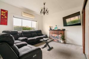 a living room with a couch and a fireplace at Joshi's Villa in Seymour