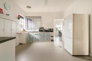 a kitchen with white cabinets and a refrigerator at Joshi's Villa in Seymour