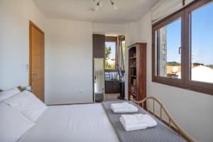 a bedroom with a bed with two towels on it at Halkidiki Sunhouse in Paliouri