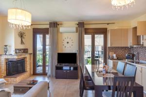 a kitchen and living room with a television and a fireplace at Halkidiki Sunhouse in Paliouri