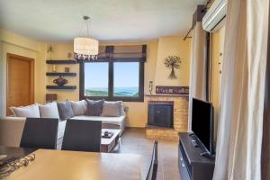 a living room with a couch and a fireplace at Halkidiki Sunhouse in Paliouri