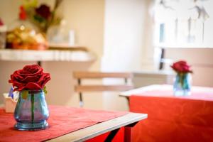 a vase with red roses in it sitting on a table at Mondo Antico in Rome