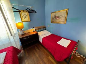 a bedroom with two beds and a desk with a red blanket at Lovenice Center Royalclass in Venice