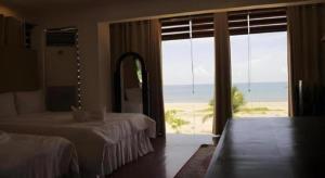 a bedroom with two beds and a large window at Jamont Hotel in Sipalay