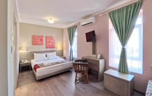a bedroom with a bed and a desk and a chair at Melina Hotel - Central in Polygryos