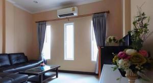 a living room with a couch and a table with flowers at Belleville hotel in Phetchabun +52 photos