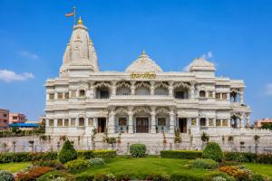 a large white building with a garden in front at Hotel Mero Vrindavan in Chhatikara