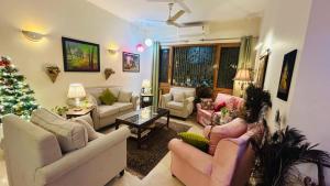 a living room with couches and a christmas tree at Dr Balis Bliss Homestay in New Delhi