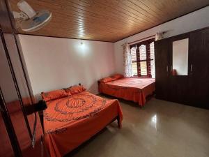 a bedroom with two beds and a window in it at Kds Homestay in Gonikoppal