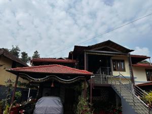 a house with a staircase leading up to it at Kds Homestay in Gonikoppal