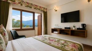 a hotel room with a bed and a large window at Mount Himalayan Hotel in Gangtok